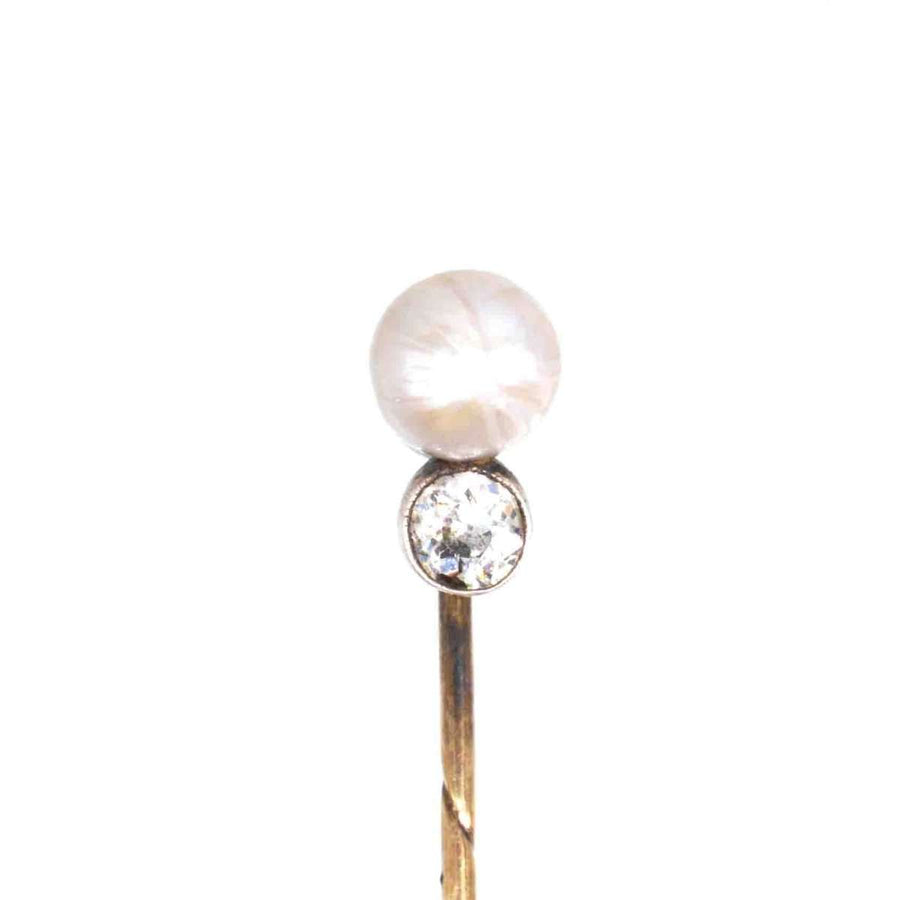 Edwardian 15ct gold tie pin featuring a natural pearl and a brilliant diamond, symbolizing elegance and refinement.