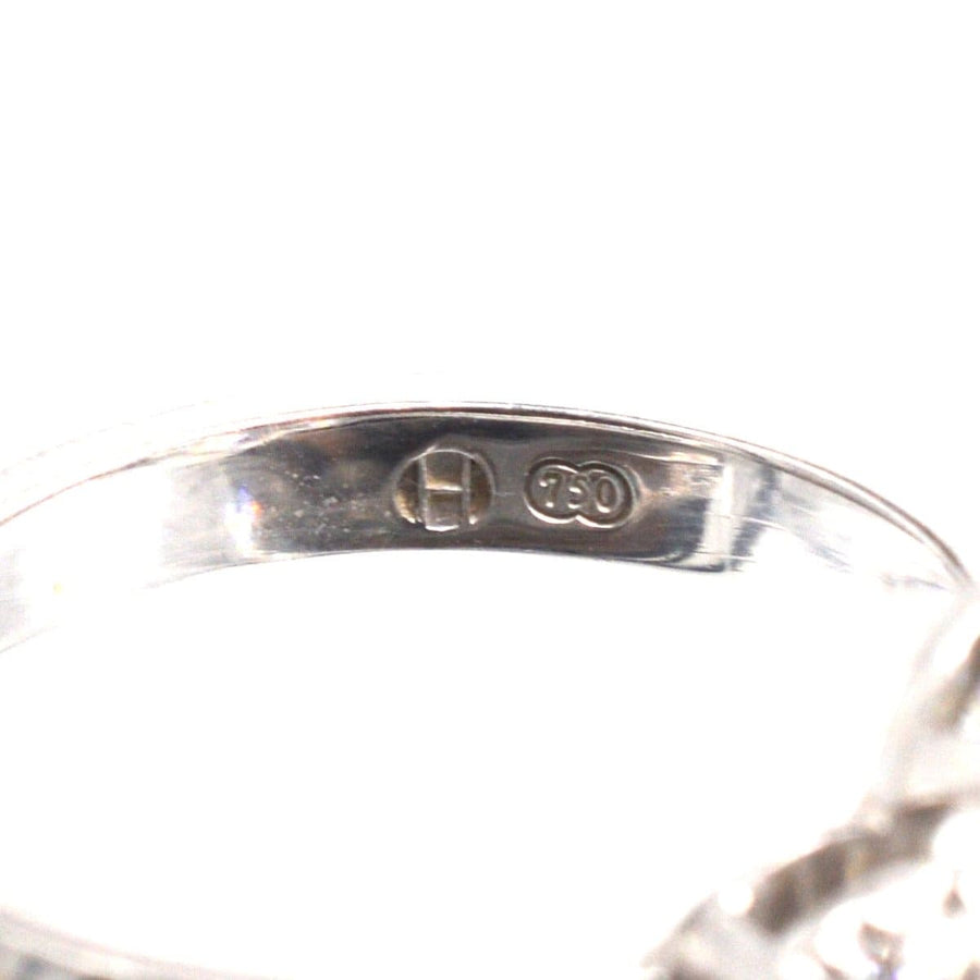 Close-up of the inner band of a modern three stone diamond cluster ring with 750 hallmark.