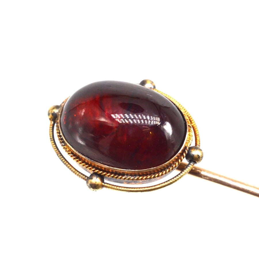 Victorian 15ct gold cabochon garnet tie pin showcasing a rich red stone, circa 1860s-1880s, perfect for elegant attire.
