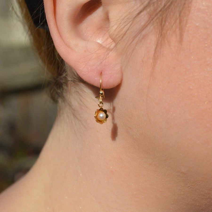 Vintage 1970s 9ct gold and pearl flower earrings worn, showcasing their charm and elegance.