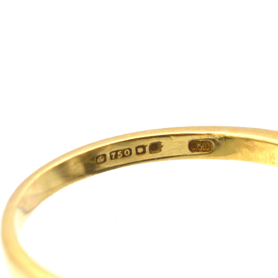Close-up of the hallmark on a vintage 18ct gold ring, showing the 750 stamp and London jewelry marks.