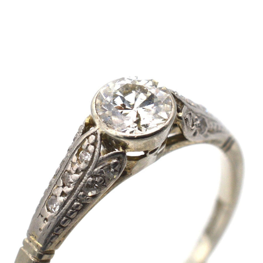 Art Deco 18ct gold and diamond solitaire ring with detailed shoulders and 0.40 carat diamond centerpiece.