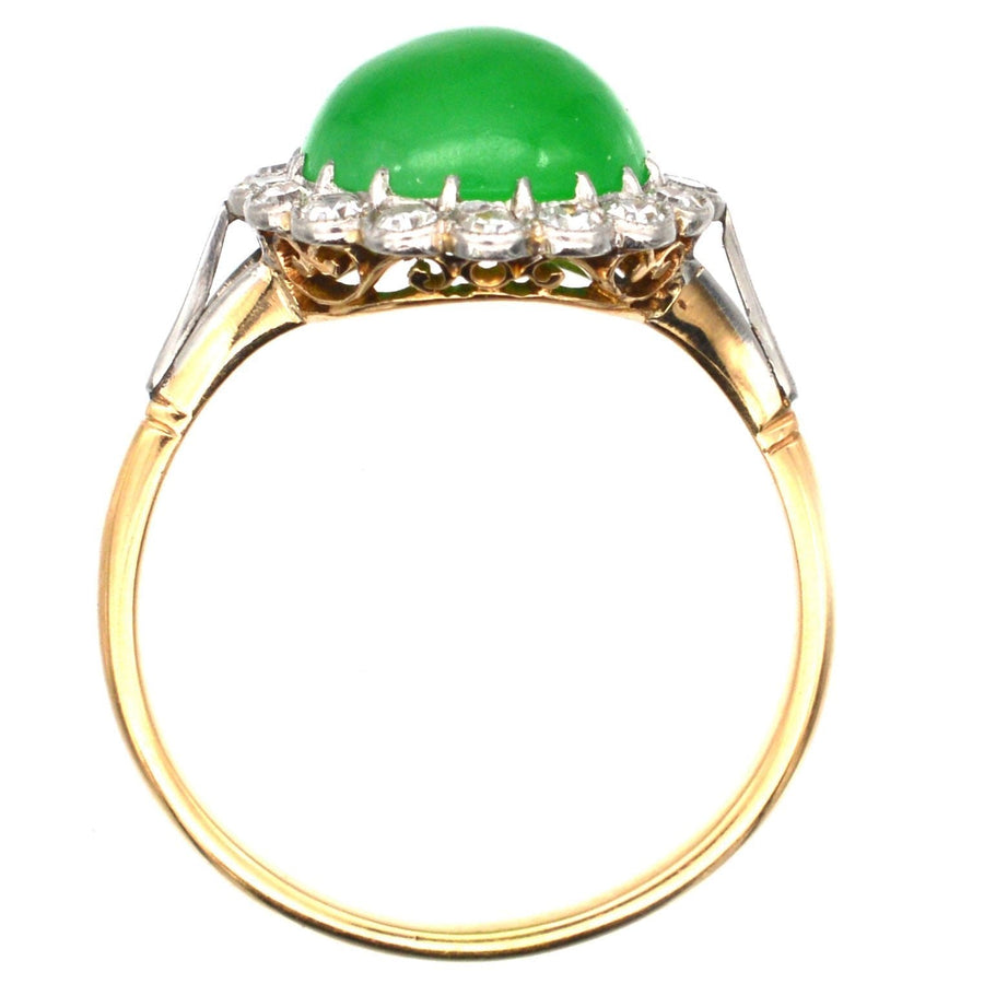 Art Deco 18ct gold ring featuring a vibrant green jadeite cabochon and diamond cluster setting.