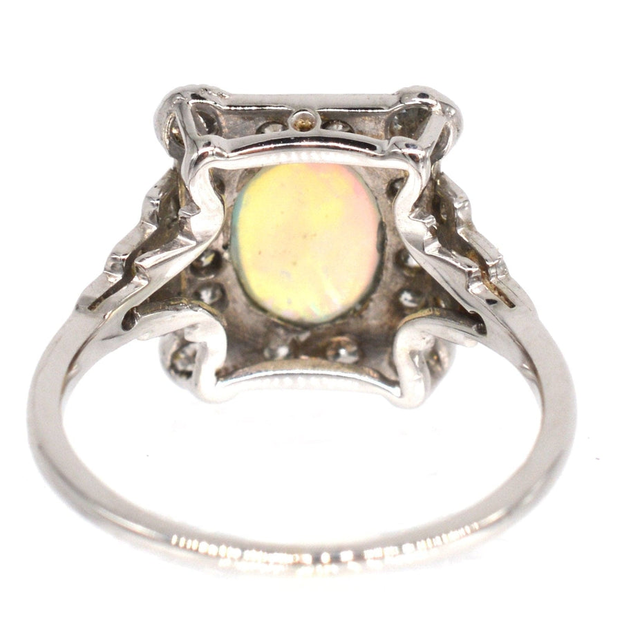 Art Deco 18ct gold and platinum ring with a vibrant opal and diamond setting, featuring intricate design details.