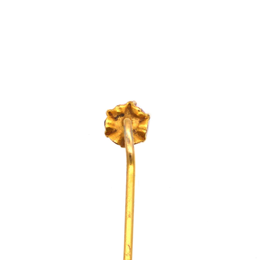 Back view of an Art Deco 18ct gold tie pin featuring a pink sapphire, showing texture and craftsmanship.