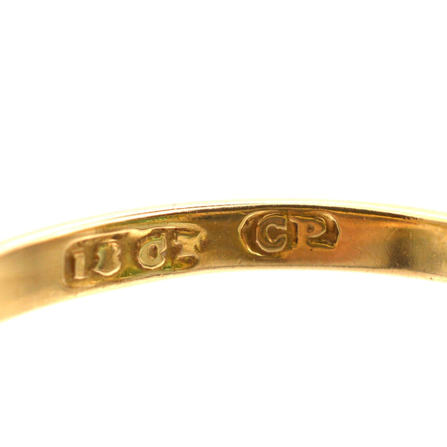 Close-up of the hallmark on an 18ct gold ring, displaying quality stamps for authenticity.