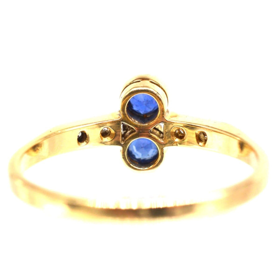 Art Deco ring in platinum and 18ct gold featuring two vibrant sapphires and diamond accents, perfect for an engagement or gift.