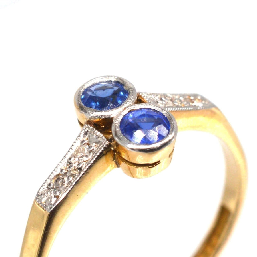 Art Deco platinum and gold sapphire and diamond ring featuring vibrant blue sapphires and intricate detailing.
