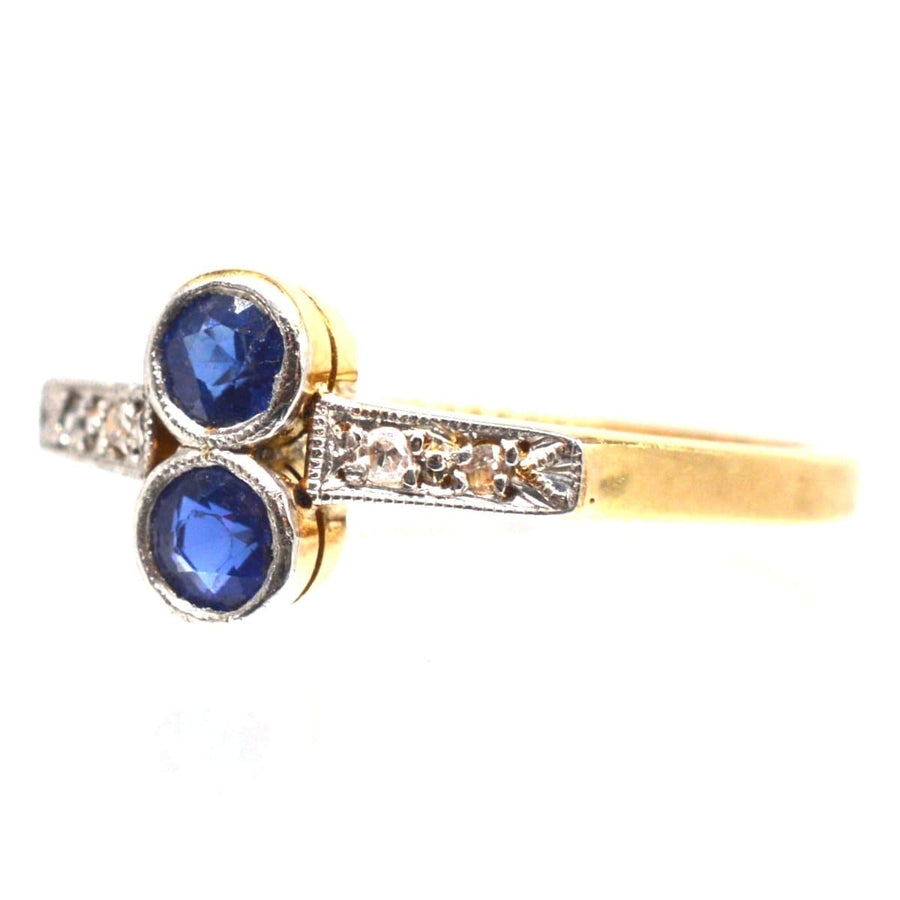 Art Deco platinum and 18ct gold ring featuring two blue sapphires and diamond accents, perfect as an engagement ring or gift.
