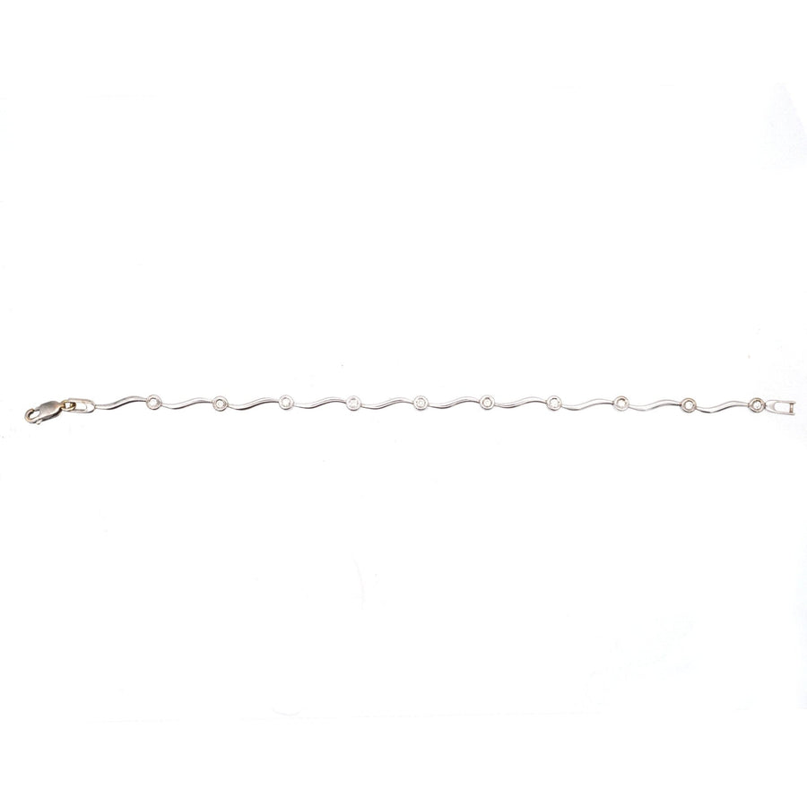 Modern 9ct white gold wavy diamond bracelet featuring 10 sparkly diamonds in a bezel setting, elegant and timeless.